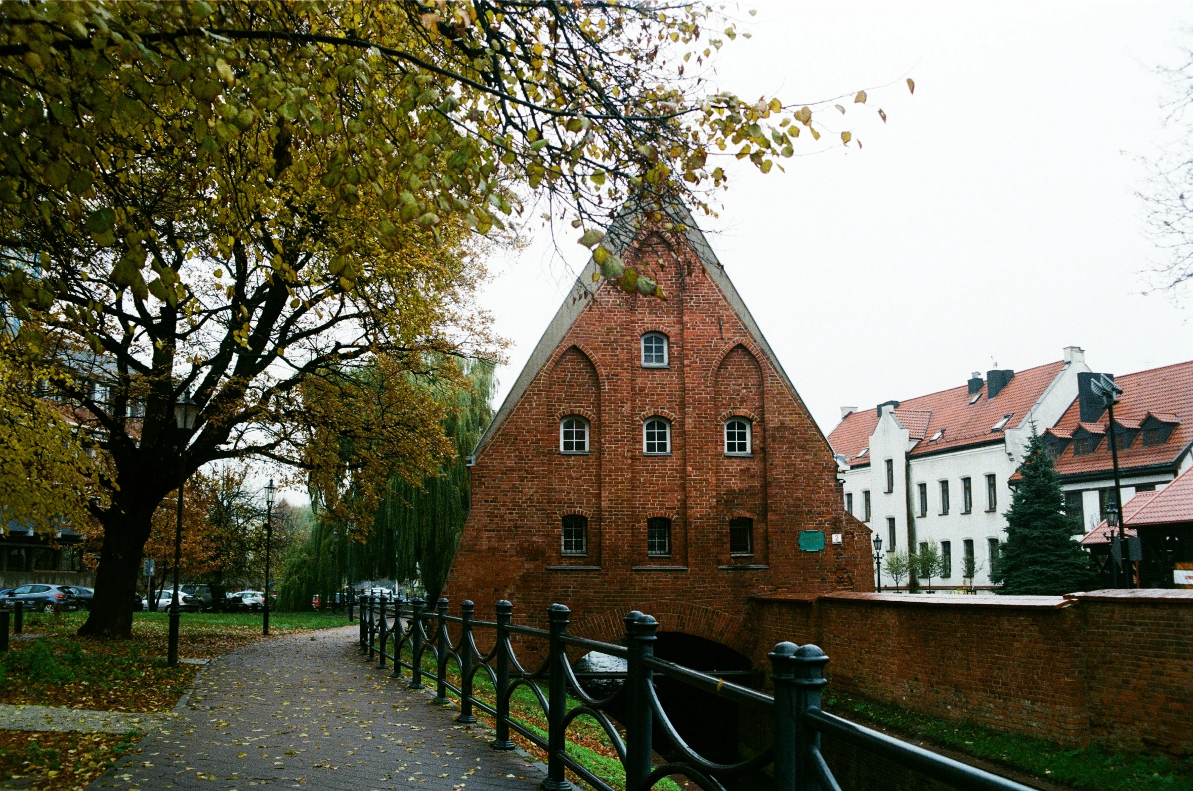 a brick house sits behind a gate on a path