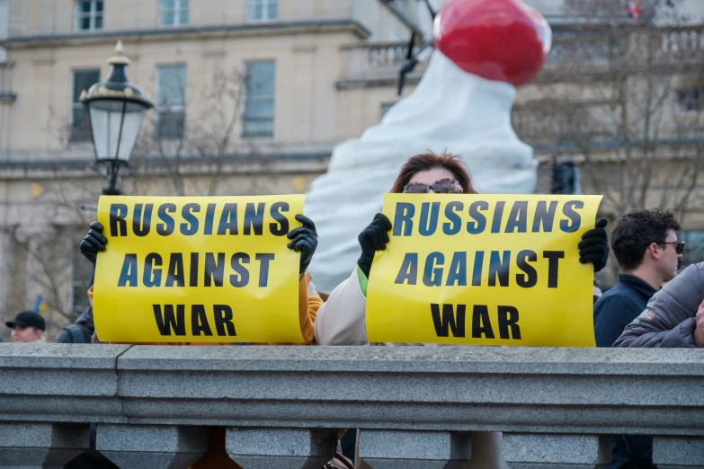 protesters at an anti - war demonstration on the bridge outside of the kreme tower