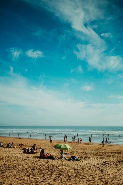 many people on a beach by the ocean