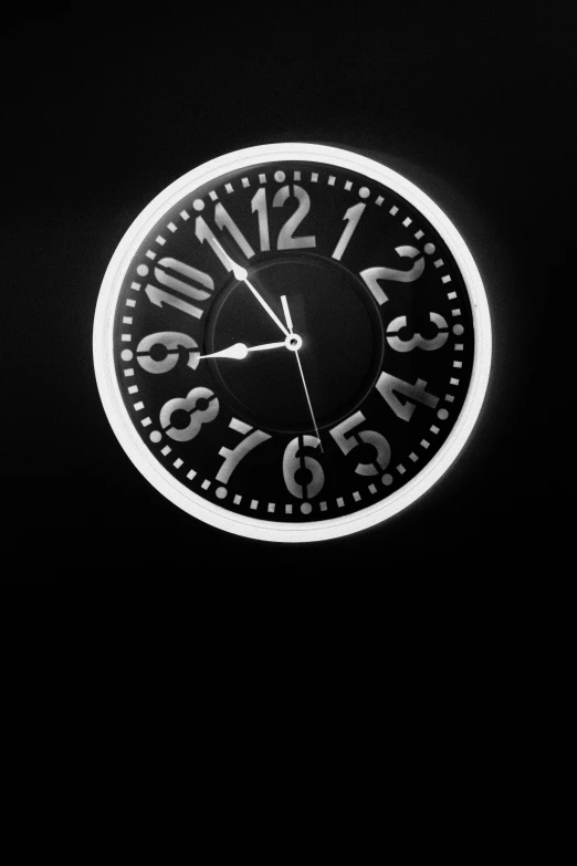 a clock is lit up on a dark surface