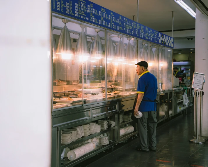 a man standing in front of an empty deli counter
