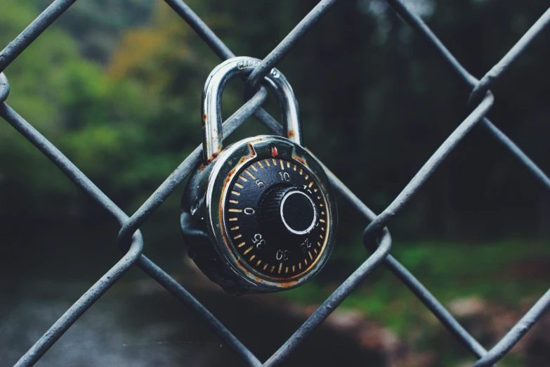 a padlocked on a fence that is very large and has a nice lock to it