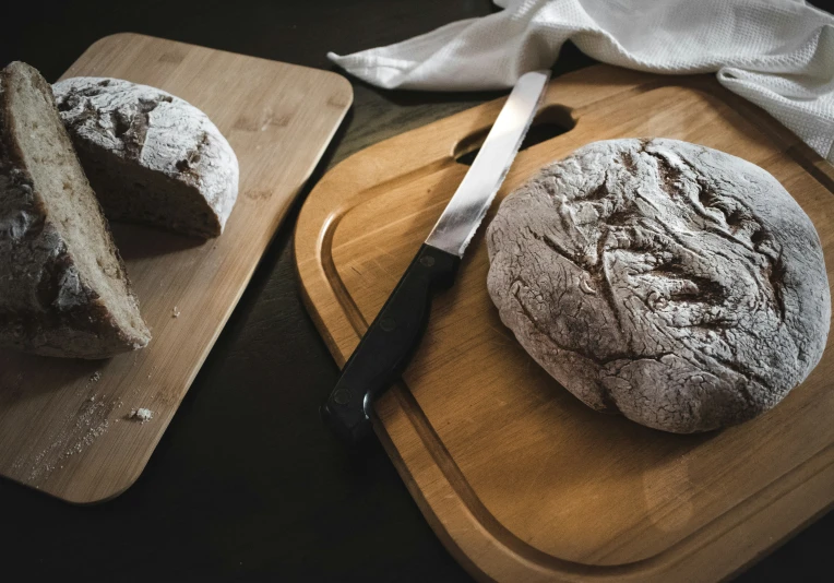 a wooden  board with a round bread on top of it