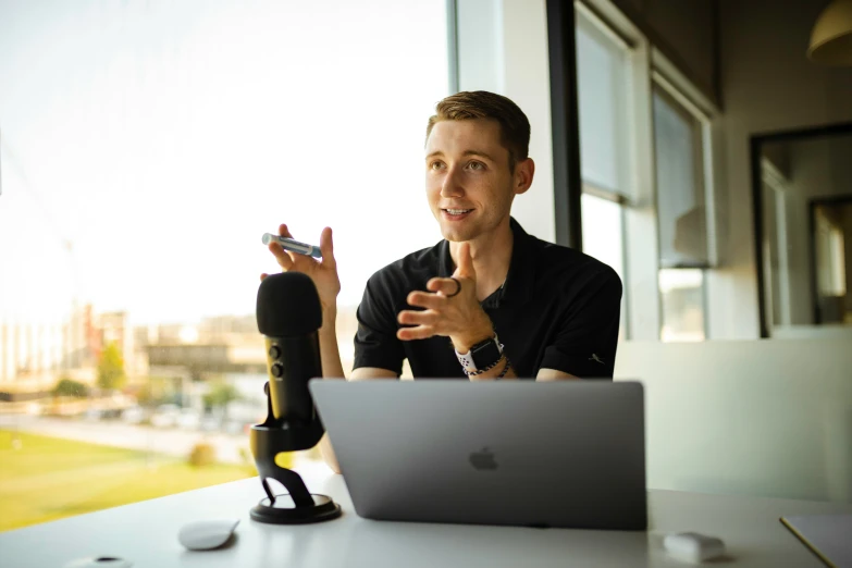 a man sits at a table in front of a laptop