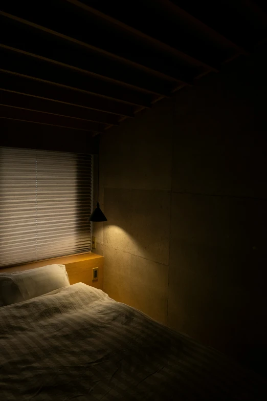 a bedroom with light shining in it, and a small window in the background