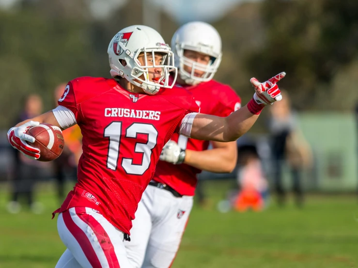 the football players are in their uniforms with their hands in the air