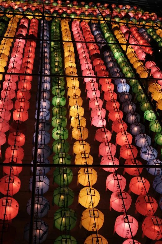 many brightly colored paper lanterns are seen in the dark