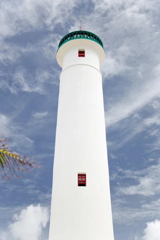 a white and red lighthouse surrounded by white clouds