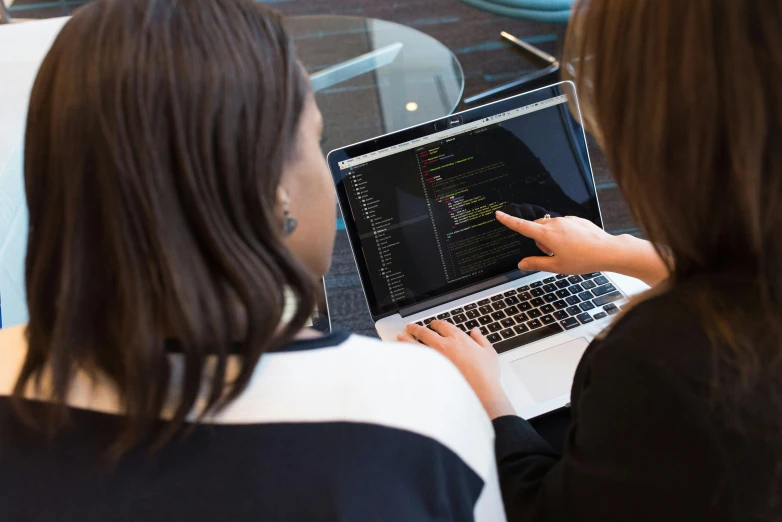 two women with laptops looking at it