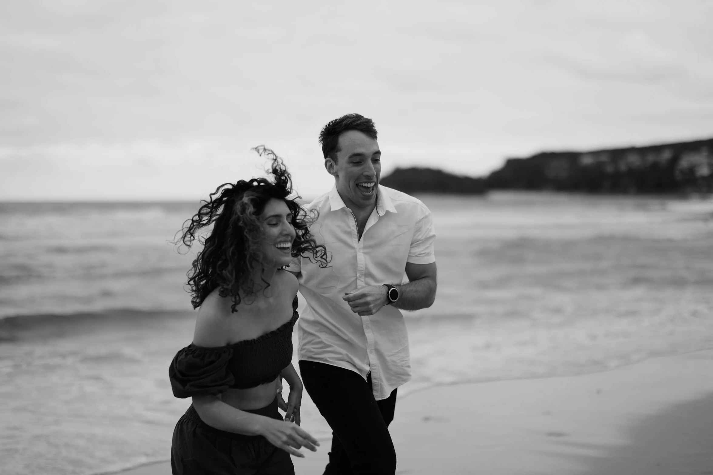 a man and woman standing next to each other on the beach