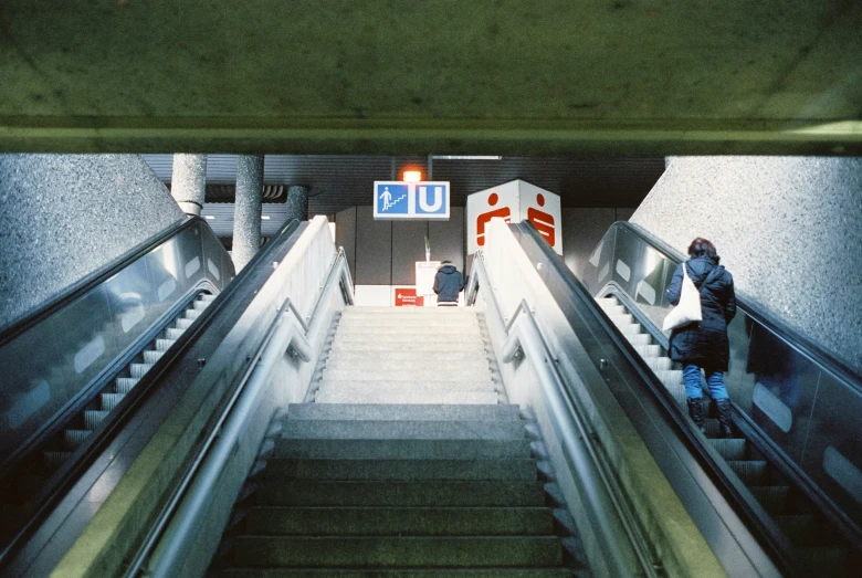 a person on an escalator waiting at the exit