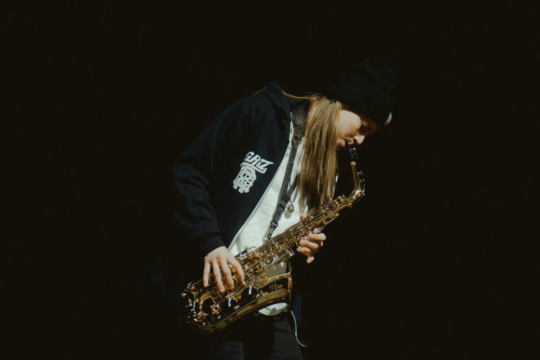 a man playing a saxophone in front of a dark background