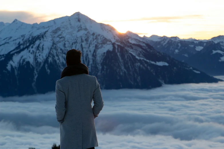 the woman is looking at the snowy mountain peaks