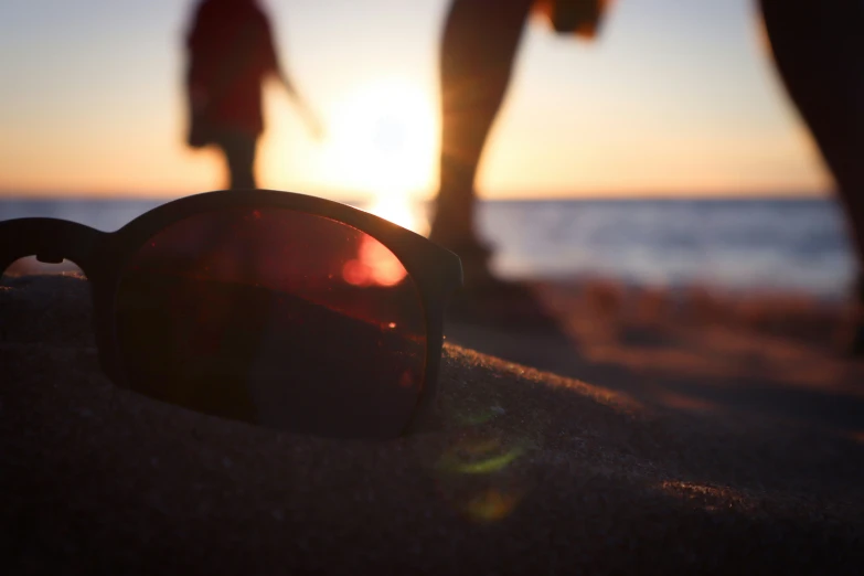 a couple is seen walking on the beach at sunset