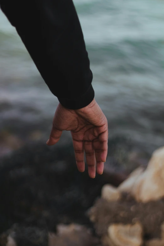 a person's hands holding out on a rock