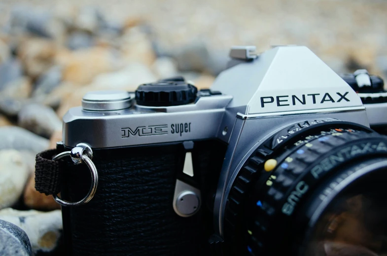 an analog camera has a pentax key chain attached