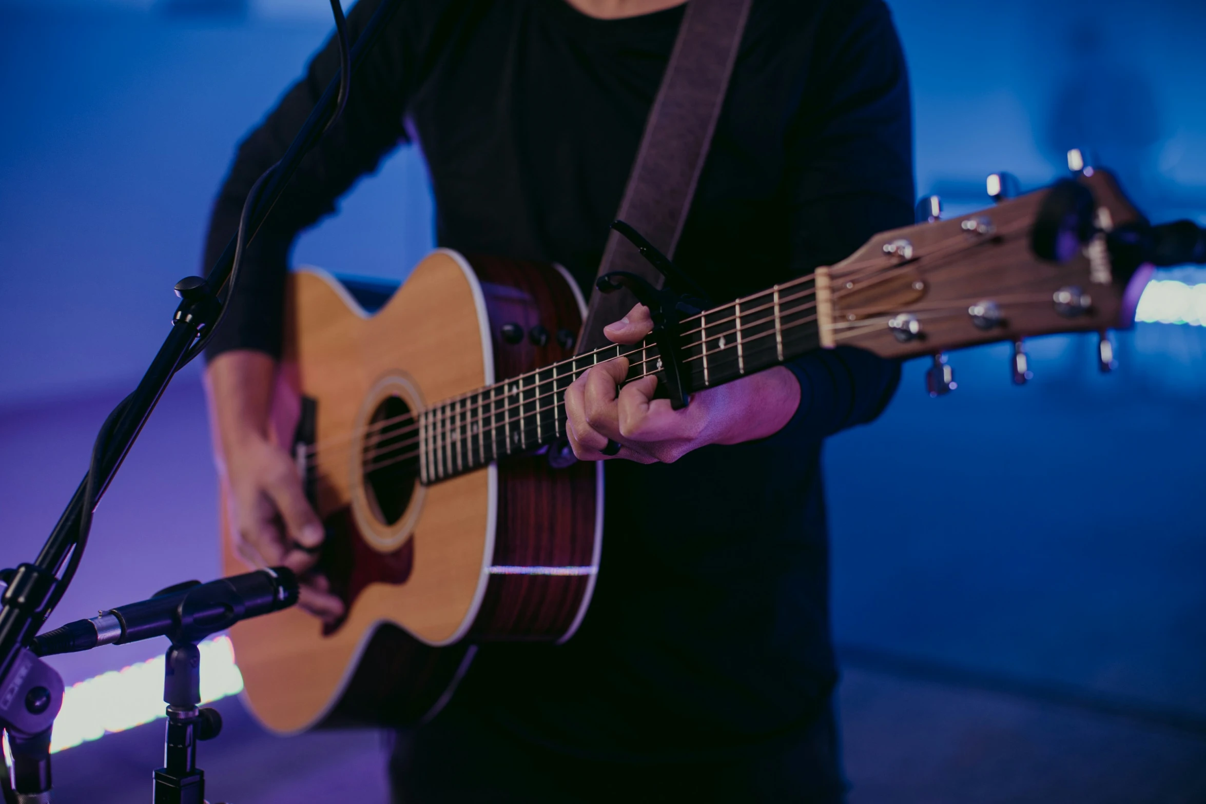 a person holding a guitar next to microphone