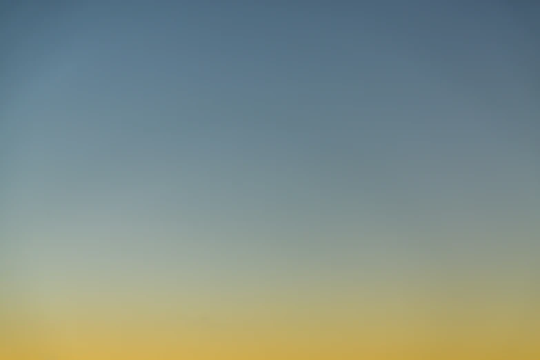 a group of four planes flying in the sky at dusk