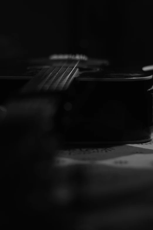 a guitar resting on the table in a dark room