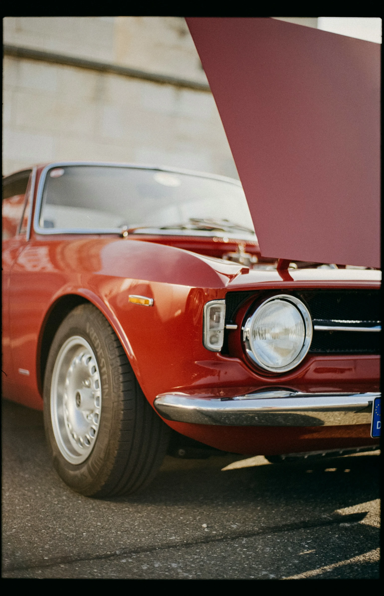 an older car with its hood up and no engine