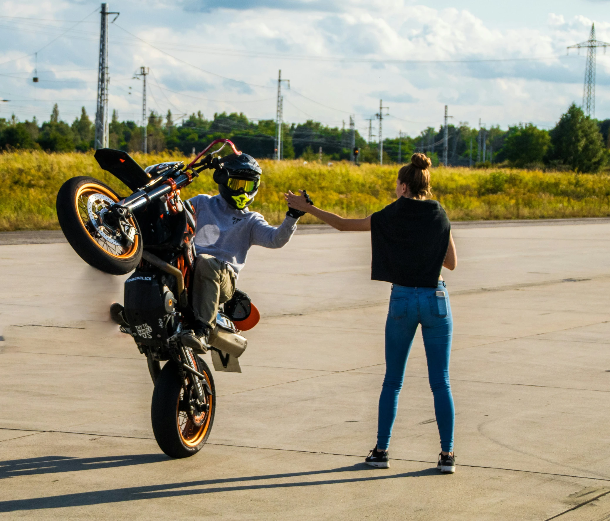 a person riding a motor bike and giving it to another persons