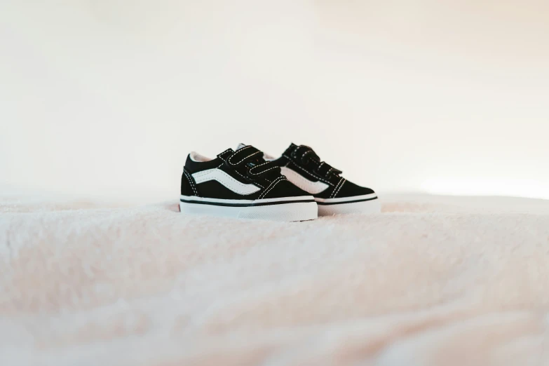 a black and white sneakers is sitting on a bed