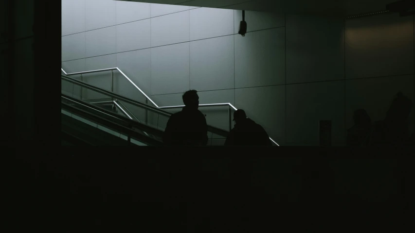 two people walking down a staircase in the dark
