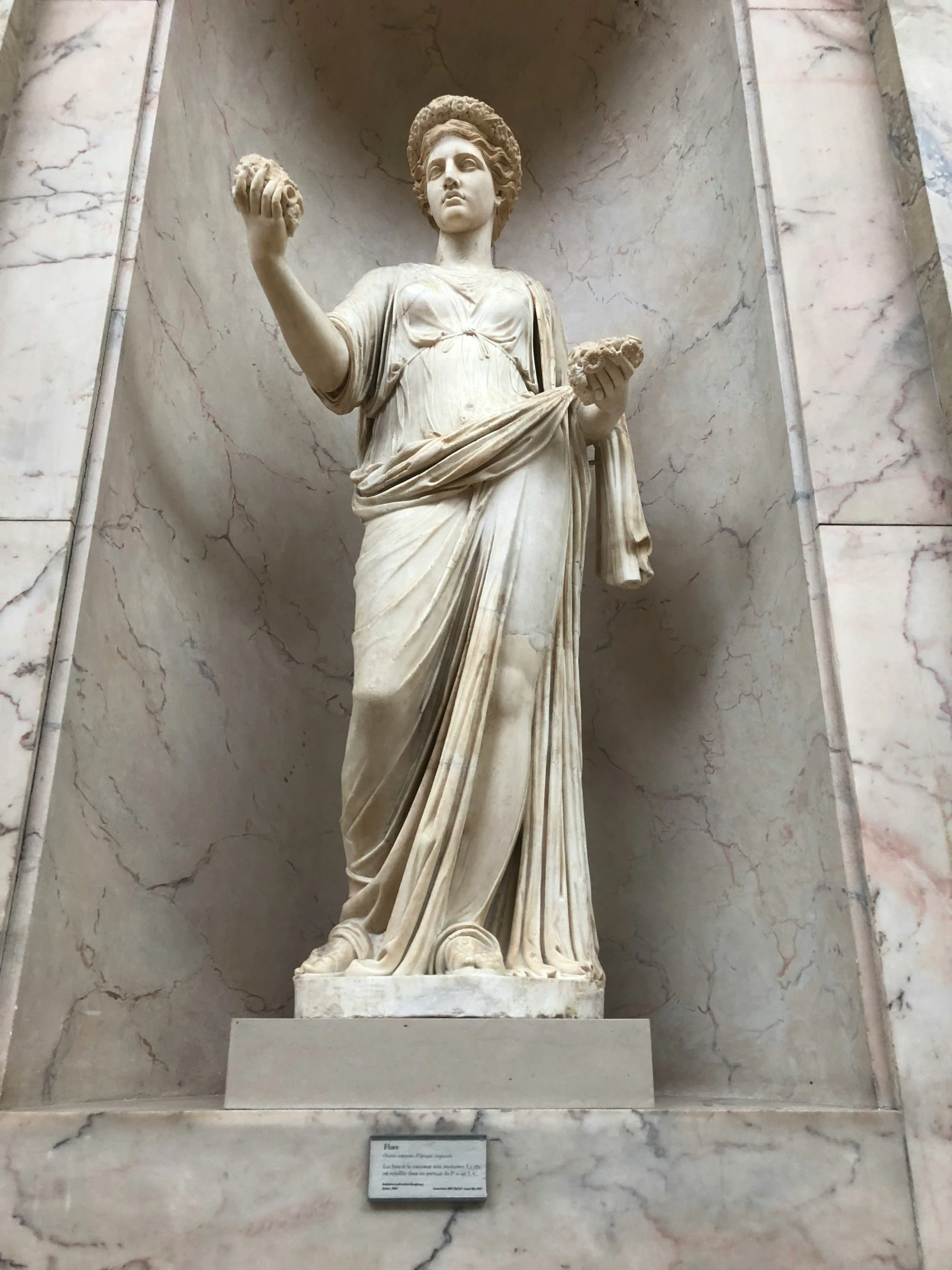 a statue in a large room with marbles