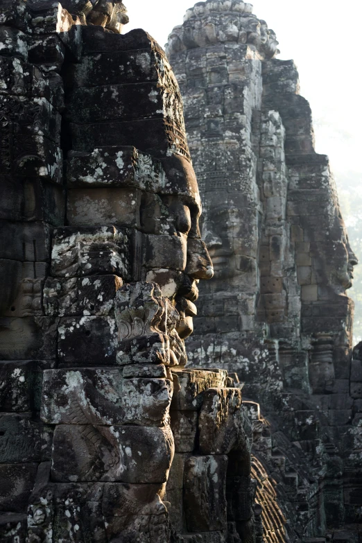 a large statue of a person stands on top of a stone structure