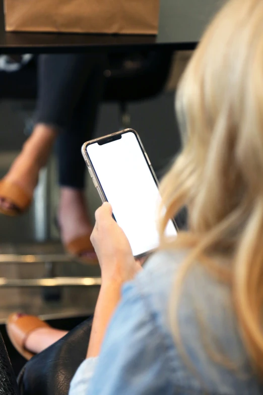 a woman in jeans is using her cell phone