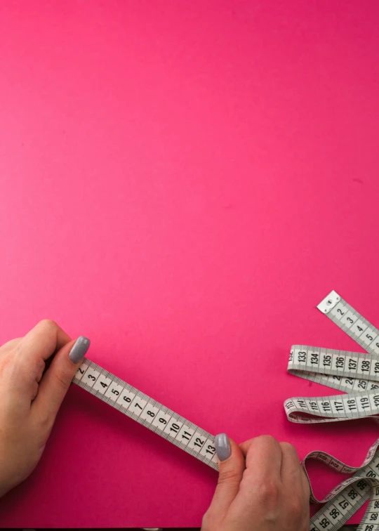 a woman's hand is using measuring tape to measure the bottom