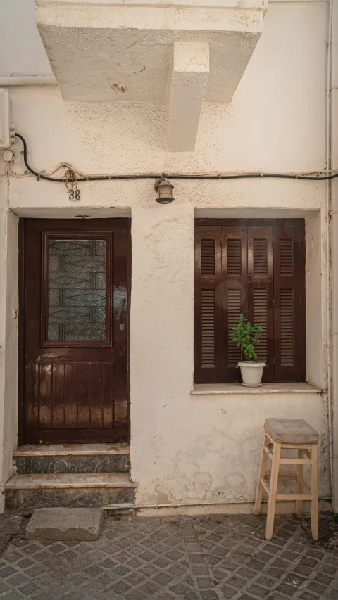 a set of doors next to a step stool with potted plants in it