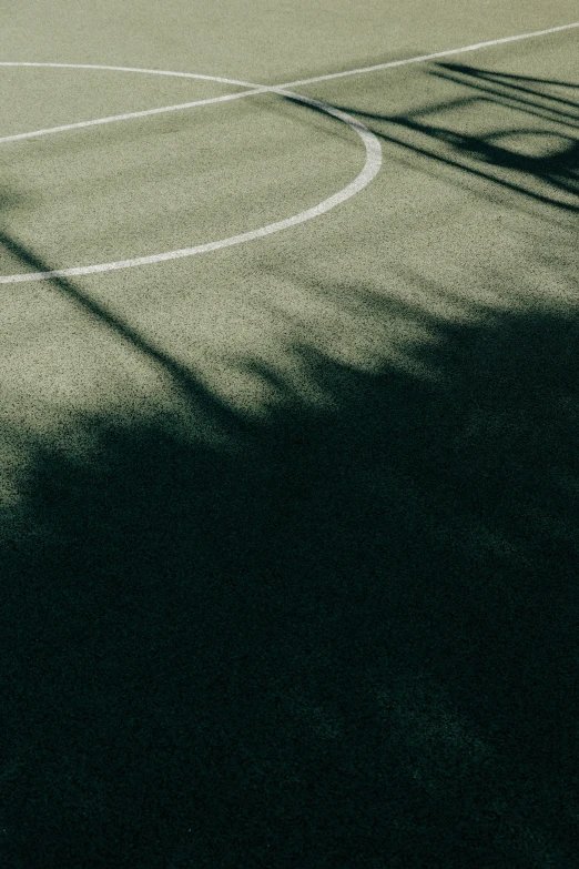 the shadow of an overhead basketball court