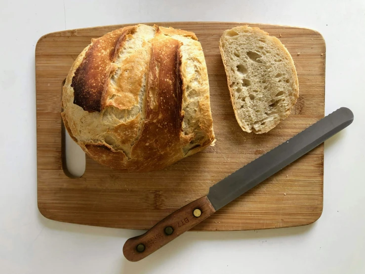a loaf of bread is next to a knife