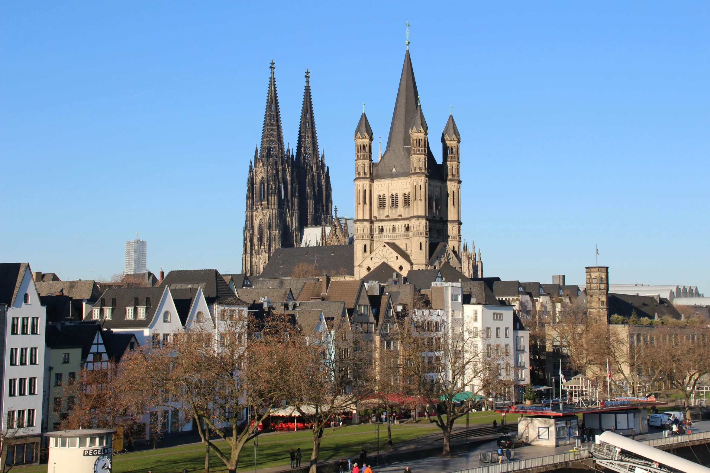 a church spire tower with several other tall buildings in the background