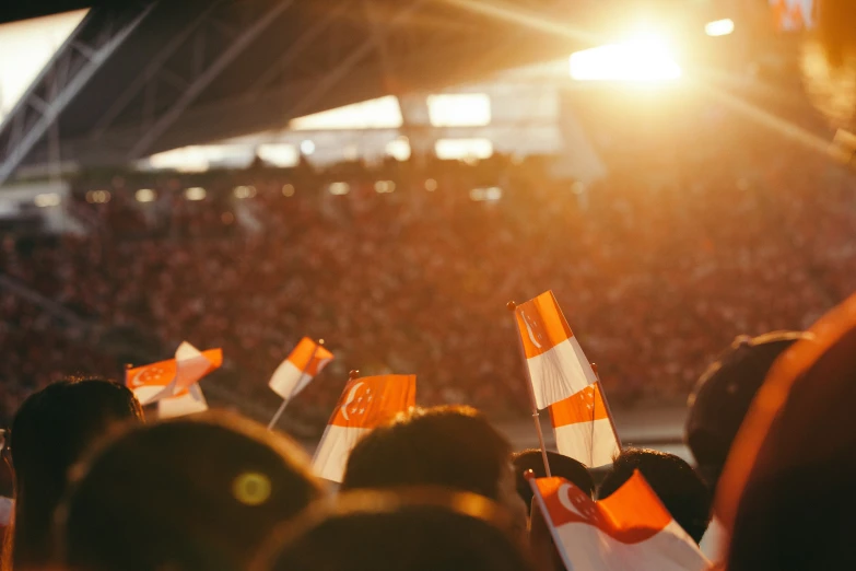 many orange and white flags are on each side of the stadium