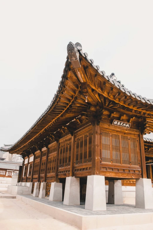 a wooden structure with wooden details with two benches at the bottom