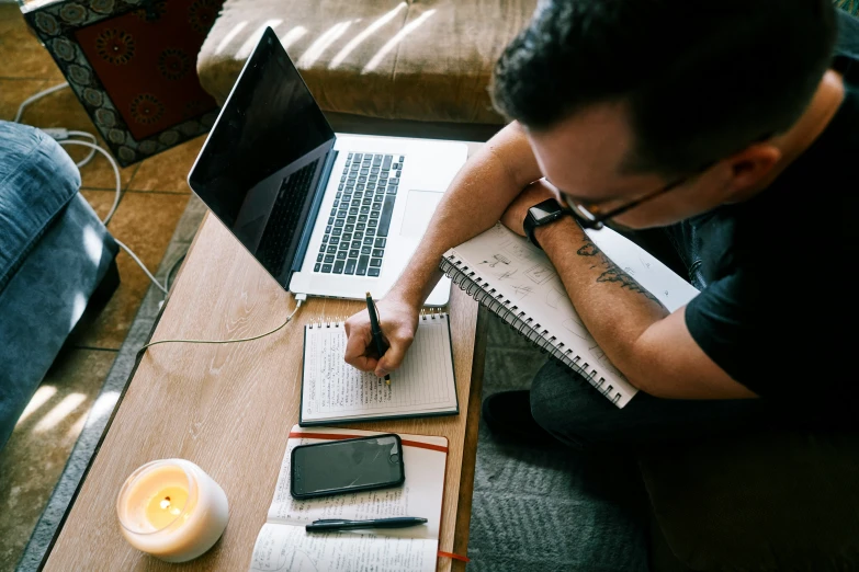 a man working on a laptop computer while sitting at a table