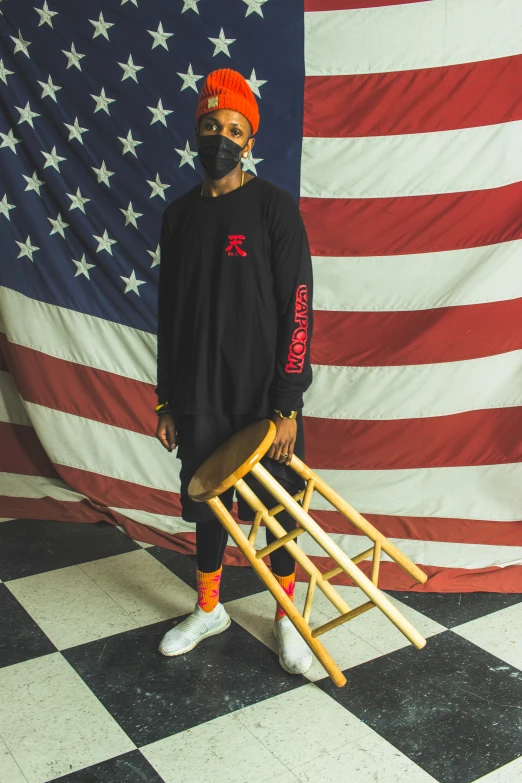 a man in black clothing standing next to a flag