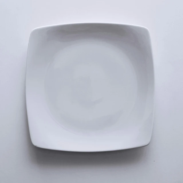 square white dinner plate sitting on top of a gray table