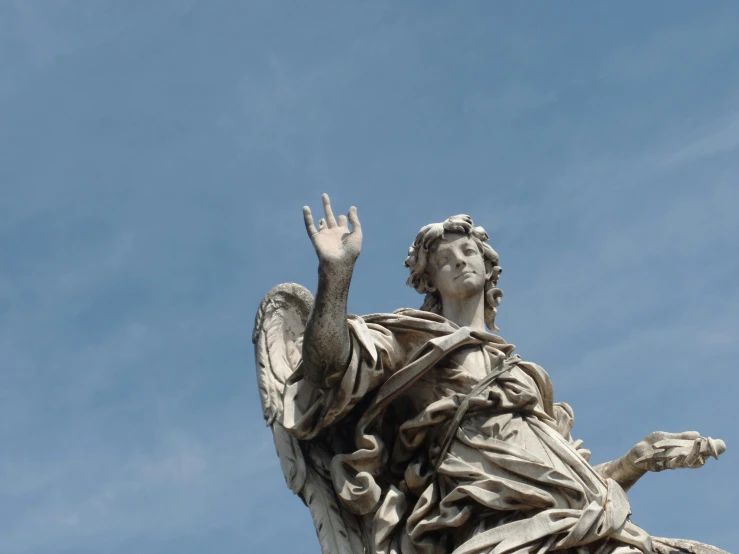 a statue is posed with outstretched arms