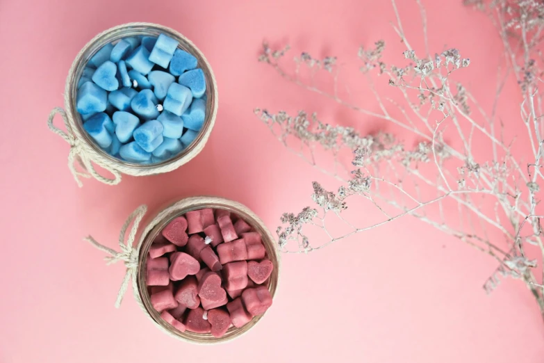 small bowls of blue and pink candy candy on a pink background