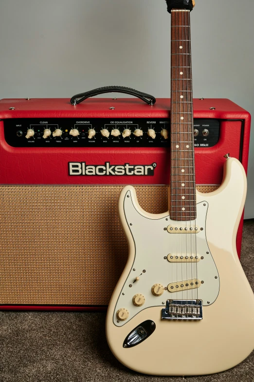 the guitar is sitting next to a red amplifier