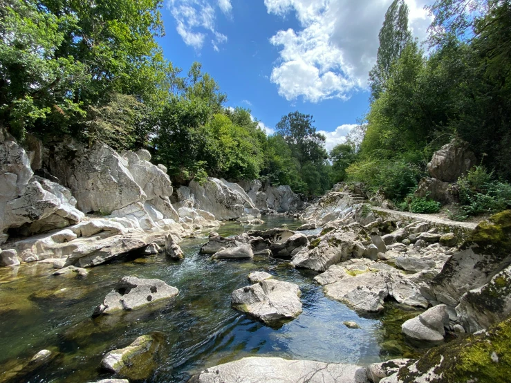 a beautiful river in a rocky area with lots of boulders and trees