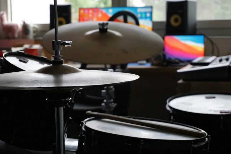 a view of an open room with a keyboard, two snarens, and drum heads