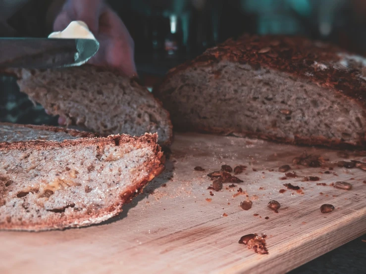 someone using a sharp knife to cut and slice bread