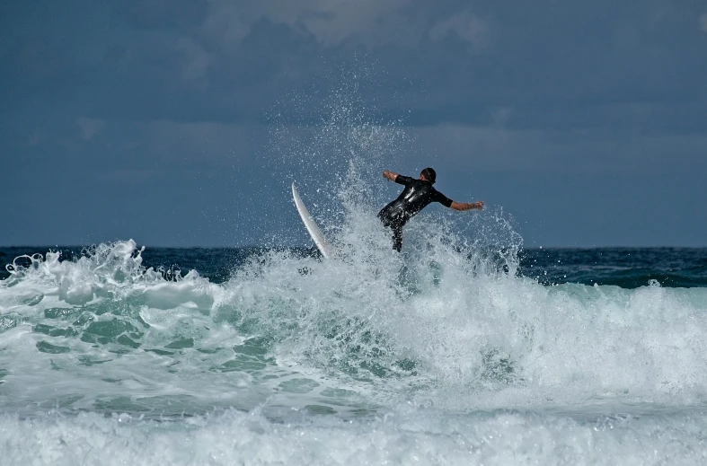 a man on a surfboard riding a wave