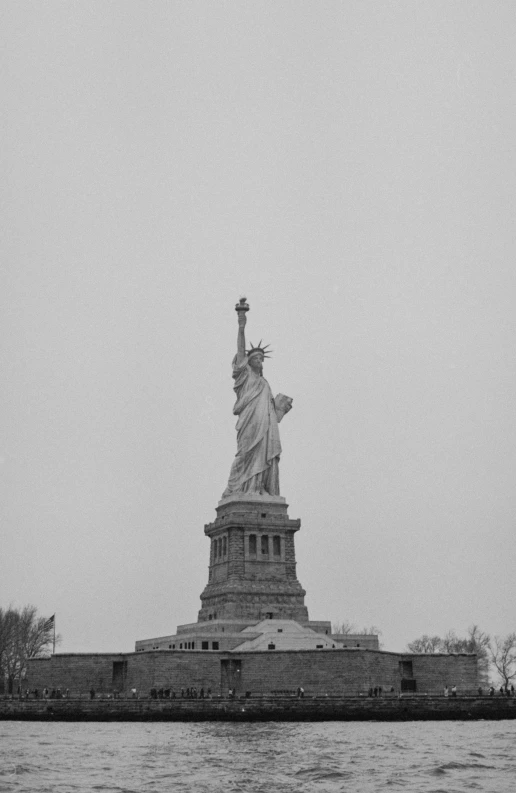 a big statue is shown near the water