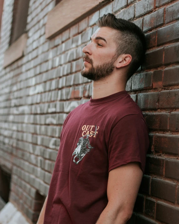 a man is standing next to a brick wall