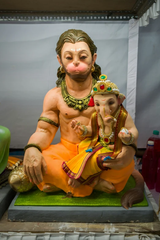 a statue of the god ganesh with an infant in his lap